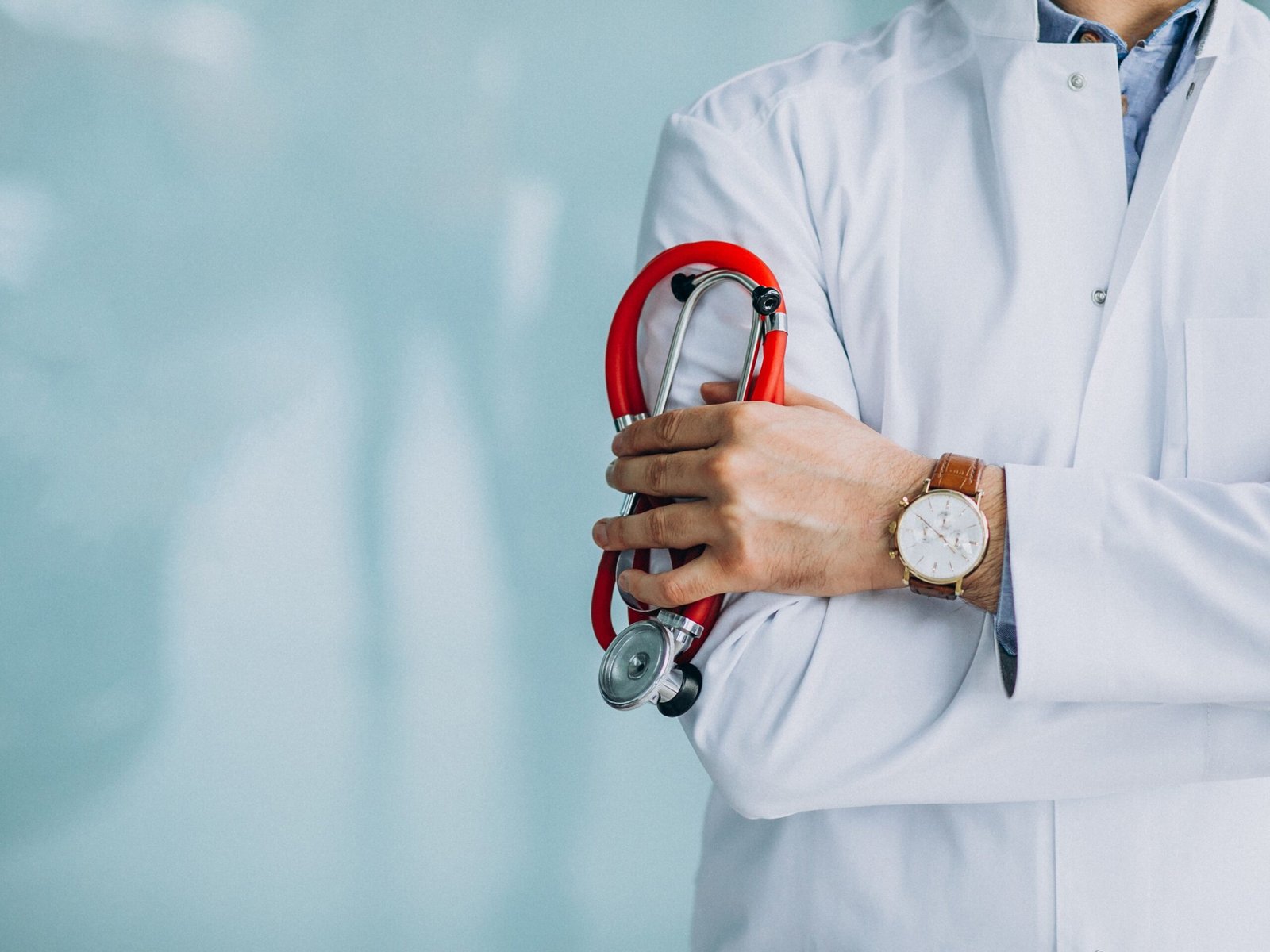 Young handsome physician in a medical robe with stethoscope