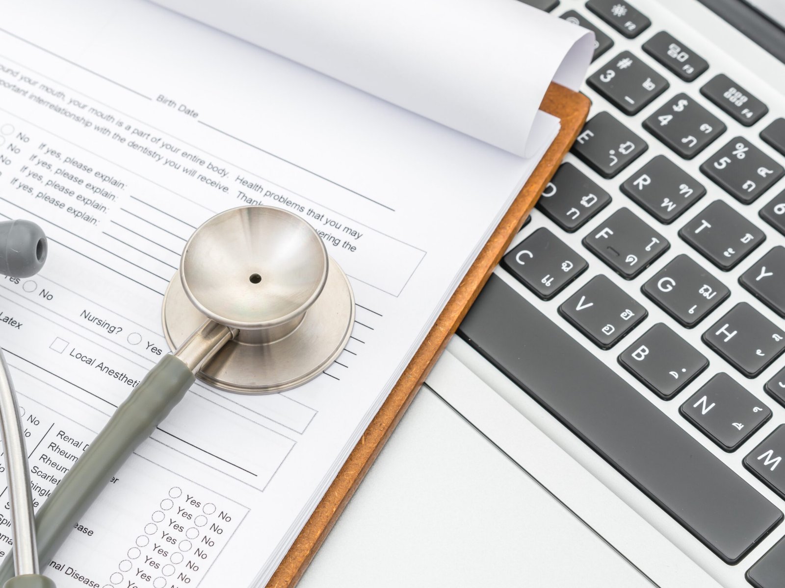 Stethoscope and prescription on laptop